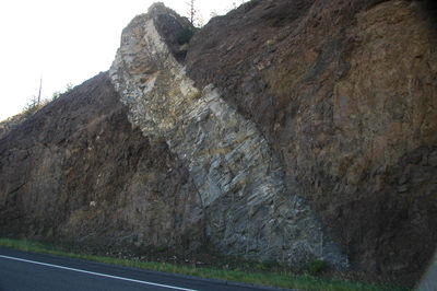 Figure 2.28: An andesite dike intrudes through a volcanic debris flow conglomerate exposed by a roadcut in the Absaroka Range, Wyoming.