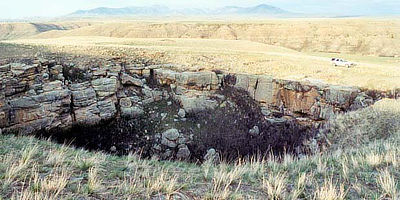 Figure 10.20: The Belt Meteor Crater southeast of Great Falls, Montana, is a sinkhole in the Madison Limestone measuring 10 meters (35 feet) deep and 30 meters (100 feet) across.
