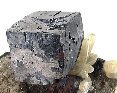Figure 5.12: A cubic galena crystal sitting atop a bed of calcite, from Reynolds County, Missouri. Specimen is 5.5 centimeters (2 inches) wide.