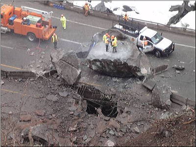 Figure 9.6: Boulders weighing as much as 60 metric tons (66 tons) are blasted and removed from I-70 at Glenwood Canyon, Colorado, after a major rockfall closed the highway. The rocks punched holes in elevated sections of the roadway; luckily, no one was injured.
