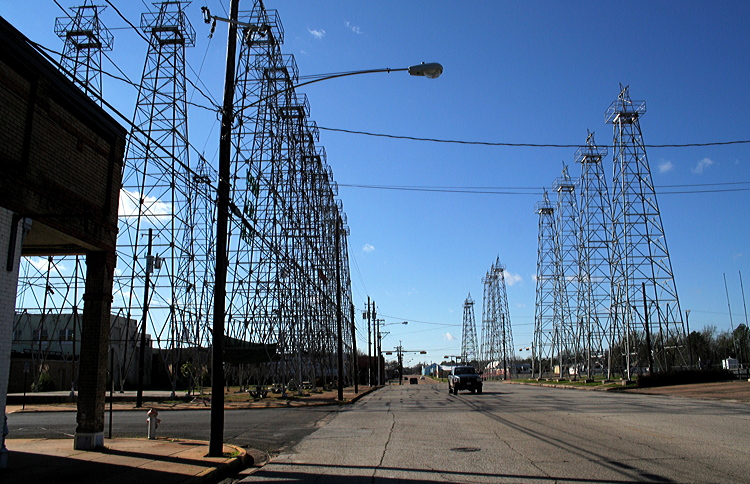 Figure 7.14: Oil derricks line a street, once known as “the world’s richest acre,” in downtown Kilgore, Texas. At the height of the Texas Oil Boom, more than 1100 oil wells operated within city limits.
