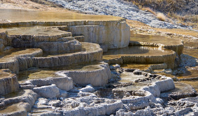 Figure 2.33: The travertine terraces of Mammoth Hot Springs in Yellowstone National Park precipitated over thousands of years as hot water from the spring cooled and deposited calcium carbonate. Over two tons of carbonate minerals in solution flow through the hot springs every day.