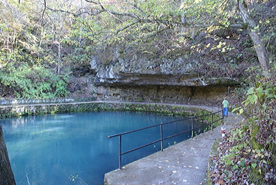 Figure 10.16: Maramec Spring, located in the east-central Ozarks, has an average daily discharge of 360 million liters (100 million gallons) of water. The spring’s opening is underwater, at the base of the dolomite overhang.