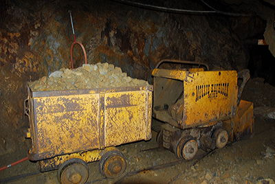 Figure 5.18: Visitors can tour the underground tunnels of the Mollie Kathleen Gold Mine, a historic vertical shaft mine in Colorado’s Cripple Creek Mining District that descends 300 meters (1000 feet) into the mountain. Many abandoned mining structures and pieces of old equipment are preserved on site, both above and below ground.