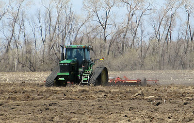 Figure 8.14: A farmer ploughs a field of rich, dark Mollisols in North Dakota’s Red River Basin.
