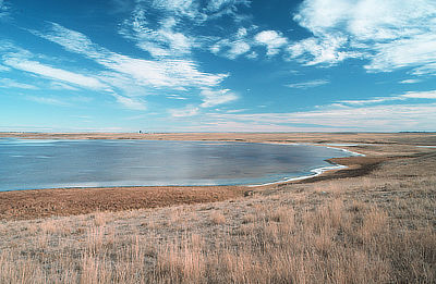 Figure 5.2: A white ring of salt can be seen around the outer rim of this evaporating playa lake in North Dakota. Typically, these shallow lakes fill up with about a foot of water during the spring and slowly dry throughout the summer, depositing layers of evaporite minerals such as halite as they diminish.