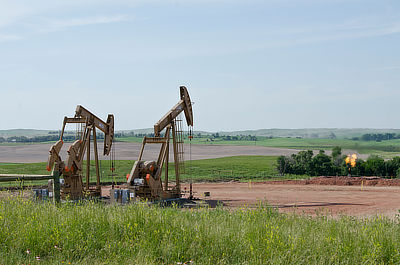 Figure 7.9: Oil pumpjacks in McKenzie County, North Dakota. The flame on the right-hand side is a flare that burns off natural gas separated from the oil.