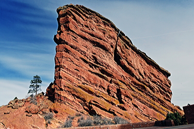 Figure 2.33: Red Rocks Park is nestled within the towering Fountain Formation in Morrison, Colorado. The formation is composed of a sedimentary rock called arkose, which is red in color due to the presence of oxidized iron and a large number of pink feldspar and quartz grains.