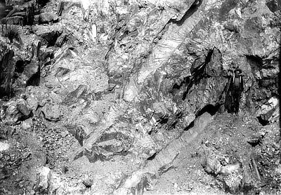 Figure 5.9: Giant spodumene crystals in the pit wall of Etta Mine, Keystone, South Dakota, in 1916. Note miner (right) for scale.