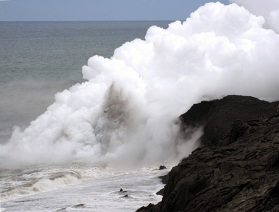 Figure 4.25: At Kīlauea a lava tube empties into the ocean creating a jet of ash and steam. Repeated interaction of lava and seawater can form littoral cones.