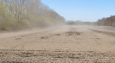 Figure 8.16: Dust rises from dry Ultisols in the Great Plains’ Prairie Pothole Region.